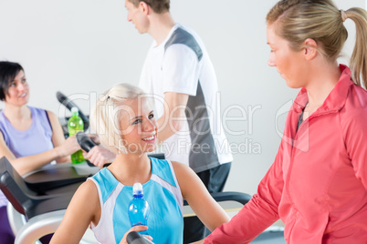 Young female friends chatting in fitness center Young female friends chatting in fitness center