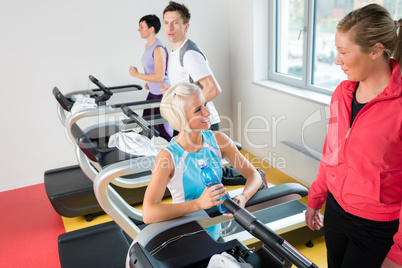 Young female friends chatting in fitness center