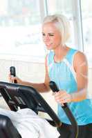 Young woman on fitness machine cardio exercise