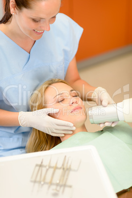 Dentist taking x-ray of female patient