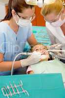 Dentist and nurse curing little girl