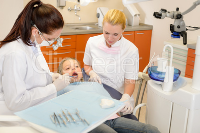 Dental assistant with dentist and little child