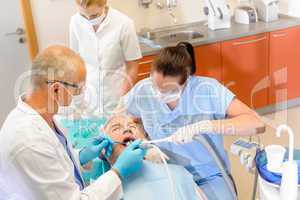 Dentist with nurses doing surgery on patient