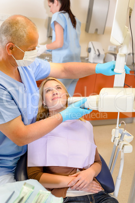 Dentist taking x-ray of female patient