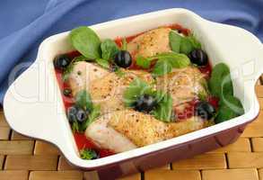 Pieces of chicken in tomato sauce with olives and spinach