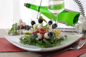 Appetizer of mozzarella, cherry tomatoes and olives with Arugula