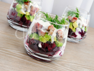 Appetizer in a glass of beet and herring with avocado