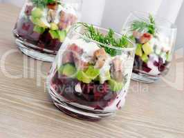 Appetizer in a glass of beet and herring with avocado