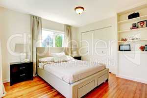 White bedroom with hardwood cherry floor.