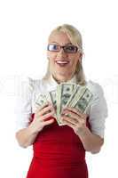 Happy blond business woman in red with money