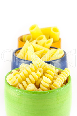 Fusilli, rigatoni and pens pasta in a green, blue and orange jar