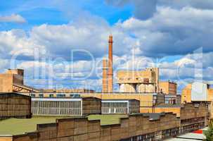 Large factory with smoking chimneys against the blue sky