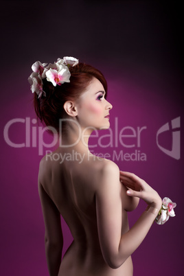 Beautiful nude redheaded woman with flowers