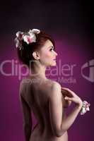 Beautiful nude redheaded woman with flowers