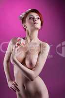 Beautiful nude young woman with flowers