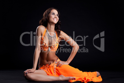 Smiling oriental dancer in orange costume