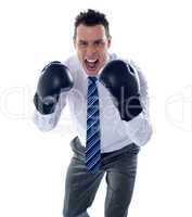 Angry corporate male wearing boxing gloves