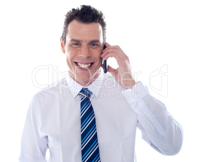 Smiling businessman attending phone call