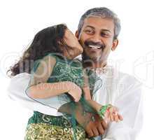 Happy Indian daughter kissing her father