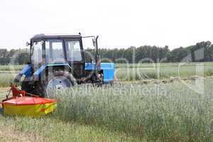 Tractor in a field, agricultural scene in summer