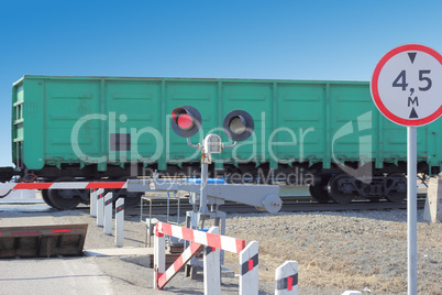 railroad cars at the crossing with a barrier