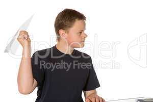 Teenager taking aim with a paper plane
