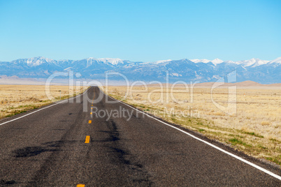 Empty freeway approaching mountains range