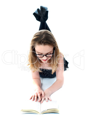 Little girl with book lying on floor