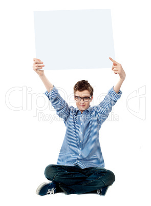 Boy pointing towards white blank billboard