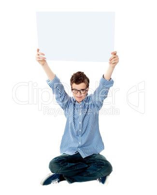 Young kid holding empty placard over his head