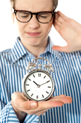 Boy irritated with noise of alarm clock