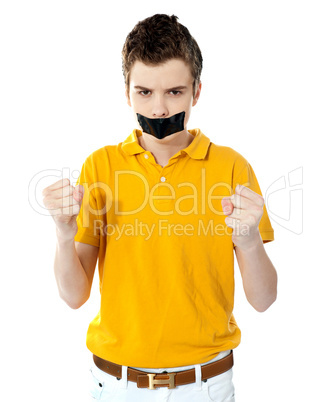 Angry boy with masking tape on mouth.