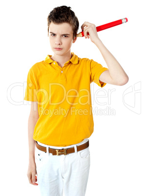 Boy cleaning his ear with big pencil