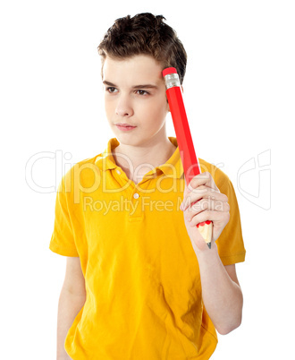 Thoughtful boy holding a pencil