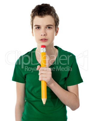 School boy thinking while holding pencil