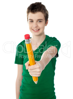 Young boy showing big yellow pencil