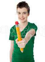 Young boy showing big yellow pencil