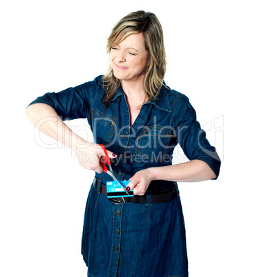 Beautiful woman cutting her credit card