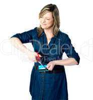 Beautiful woman cutting her credit card