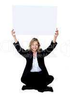 Seated female employee holding white clipboard over her head