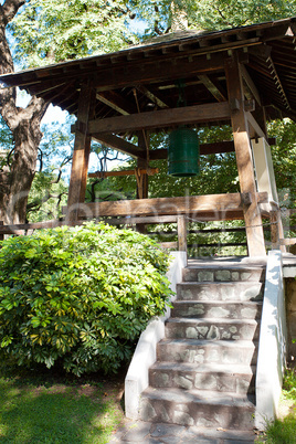 Japanese bell in the background of green trees