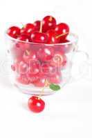 cherry with green leaf and a cup of cherries on a white backgrou