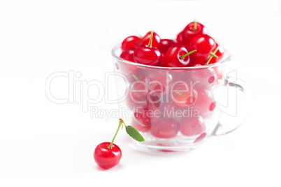 cherry with green leaf and a cup of cherries on a white backgrou