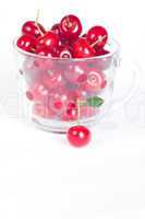 cherry with green leaf and a cup of cherries on a white backgrou