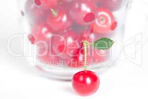 cherry with green leaf and a cup of cherries on a white backgrou