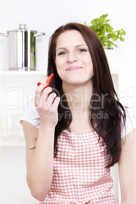 zufriedene junge frau mit einem stück paprika