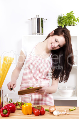 junge frau fügt paprika zu ihren salat zu