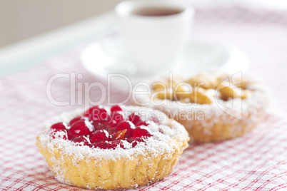 beautiful cake with berries and tea on plaid fabric