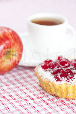 apple,beautiful cake with berries and tea on plaid fabric