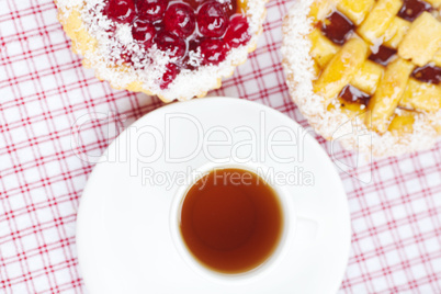 beautiful cake with berries and tea on plaid fabric